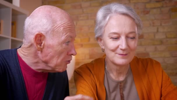 Close-up portrait of senior gray-haired caucasian spouses talking with each other being glad and happy. - Metraje, vídeo