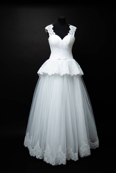 weißes Hochzeitskleid auf schwarzem Hintergrund im Studio - Foto, Bild