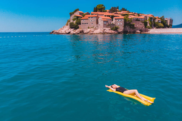 νεαρή όμορφη γυναίκα, κολύμπι στα καταγάλανα νερά. Sveti stefan παραλία - Φωτογραφία, εικόνα