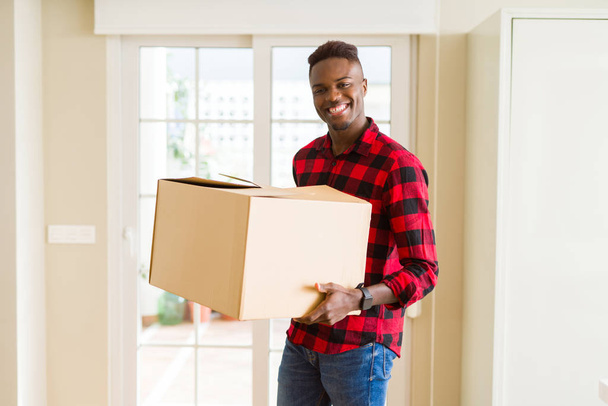 Giovane uomo africano americano in possesso di una scatola di cartone, imballaggio pacchetto di consegna di cartone a casa
 - Foto, immagini