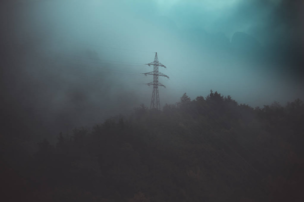 the power line is high in the mountains in the fog at sunset bef - Foto, immagini