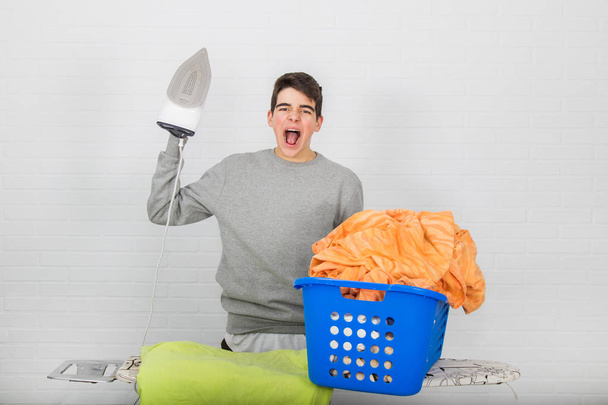 νεαρός άνδρας με προβλήματα σιδέρωμα ρούχα - Φωτογραφία, εικόνα