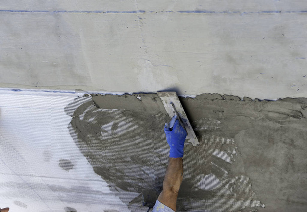 Mano con paleta sobre hormigón fresco en obra
 - Foto, Imagen