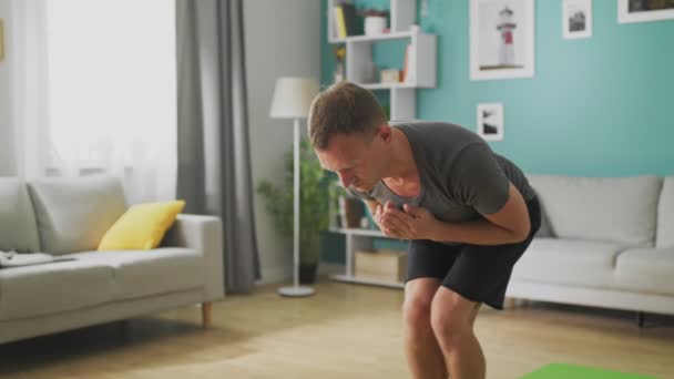 Man are doing yoga at home in the morning in his living room - Video