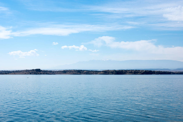 Nádherné klidné pobřeží jezera pod modrým zamračený oblohou - Fotografie, Obrázek