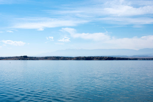 Nádherné klidné pobřeží jezera pod modrým zamračený oblohou - Fotografie, Obrázek