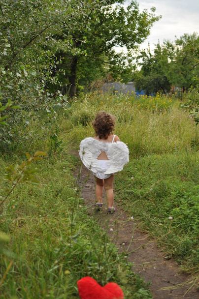 menina encaracolado com asas corre pelo caminho
 - Foto, Imagem