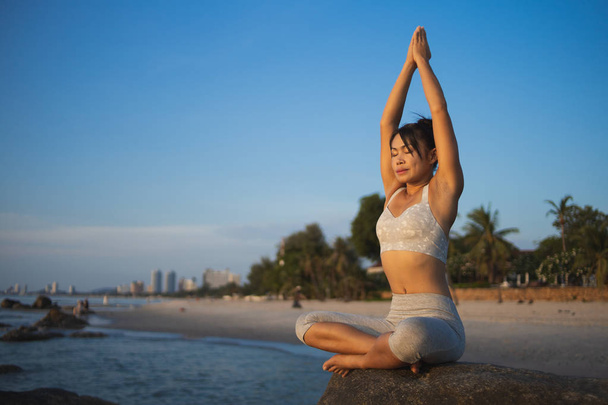 Asian girl practice Yoga on the beach Sunrise morning day - Fotoğraf, Görsel