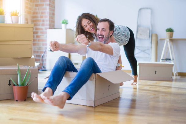 Старша романтична пара середнього віку весело катається всередині картону, схвильована і усміхнена щаслива за переїзд в новий будинок
 - Фото, зображення