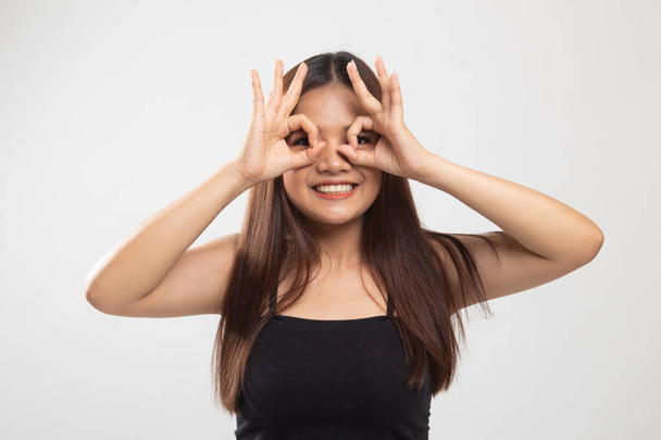 Asian woman do funny  double OK sign as glasses. - Foto, afbeelding