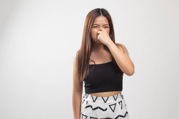 Young Asian woman  holding her nose because of a bad smell. - Фото, изображение