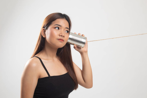 Young Asian woman with tin can phone. - Φωτογραφία, εικόνα