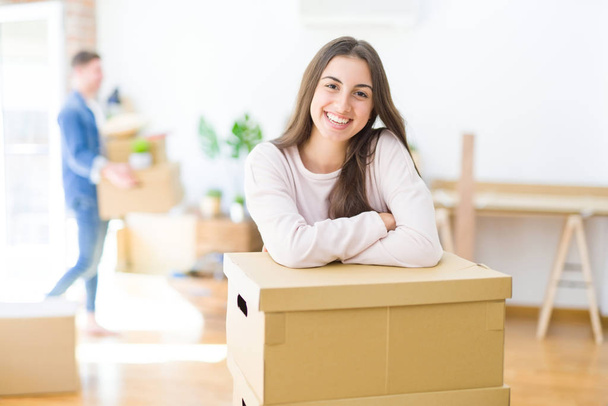 Beautiful young couple moving to a new home, young woman smiling happy to the camera excited for new apartment - Photo, Image