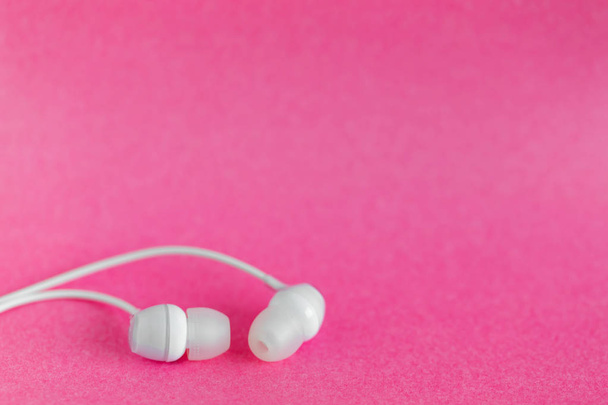 Білі навушники на рожевому барвистому фоні з місцем для копіювання тексту
 - Фото, зображення