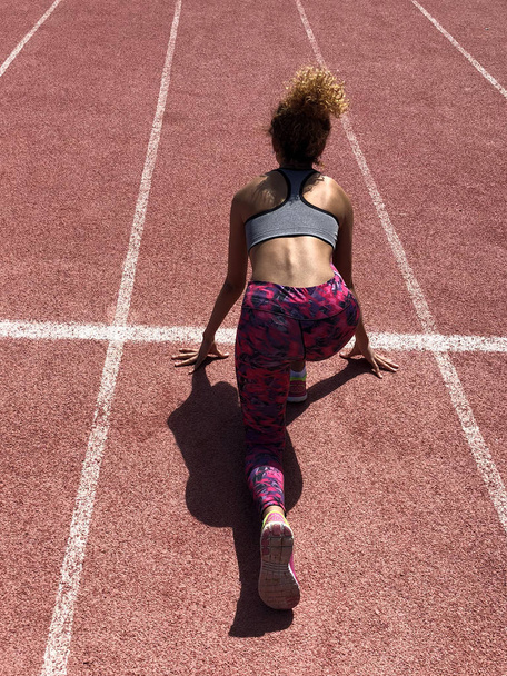 African American girl getting ready to start running in a stadium - Fotografie, Obrázek