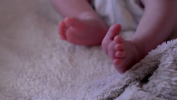bebé recién nacido está acostado y moviendo las piernas pequeñas con los dedos
 - Imágenes, Vídeo