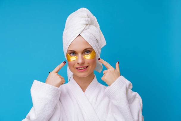 Image of woman with gel pads under eyes and towel on her head - Foto, immagini