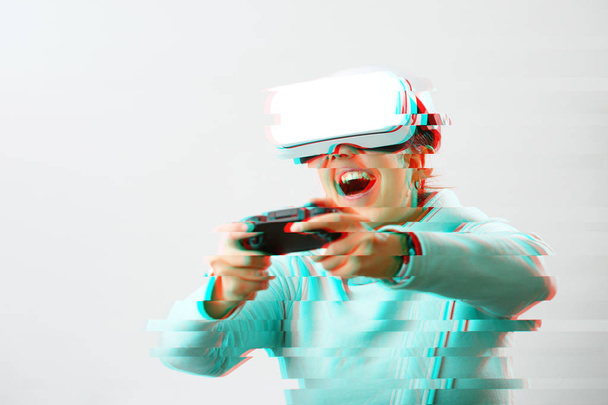 Woman with virtual reality headset is playing game. Image with glitch effect. - Photo, Image