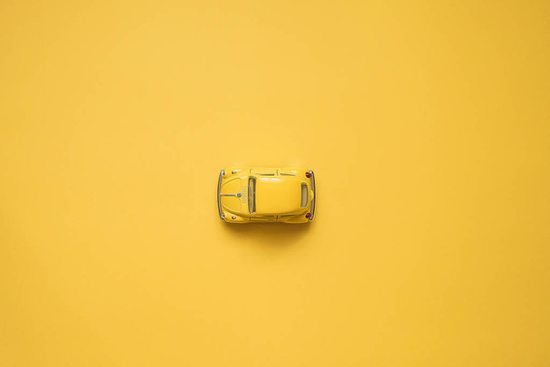 Omsk, Russia - May 26, 2019: Yellow retro toy car on yellow back - Фото, зображення