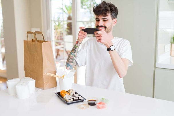 Jeune homme prenant des photos avec smartphone de sushi asiatique nourriture fr
 - Photo, image