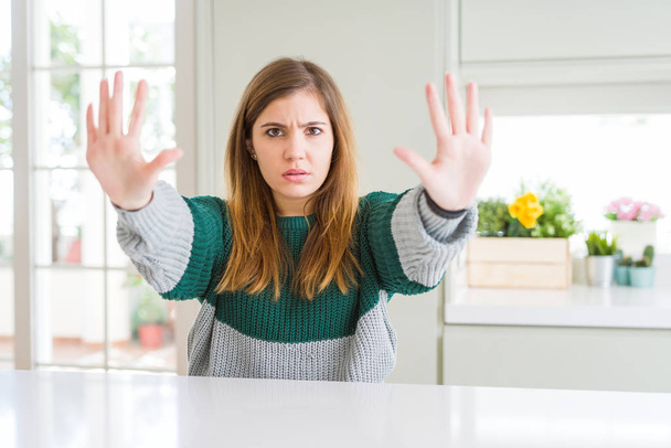 Young beautiful plus size woman wearing casual striped sweater doing stop gesture with hands palms, angry and frustration expression - Valokuva, kuva