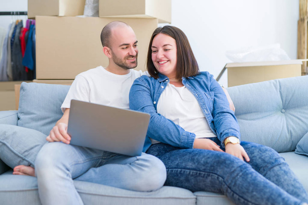 homem feliz e mulher usando laptop em casa
 - Foto, Imagem