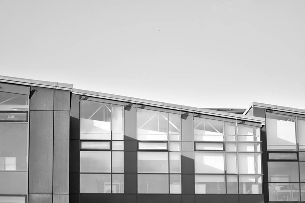 Homlokzati töredéke egy modern irodaház. Külső üveg fal absztrakt textúra. Fekete-fehér. - Fotó, kép