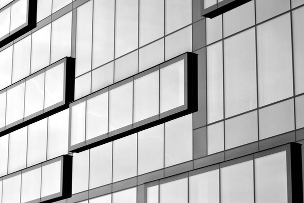 Θραύσμα πρόσοψη ενός κτιρίου σύγχρονου γραφείου. Εξωτερικά του τοίχου από γυαλί με αφηρημένα υφή. Μαύρο και άσπρο. - Φωτογραφία, εικόνα