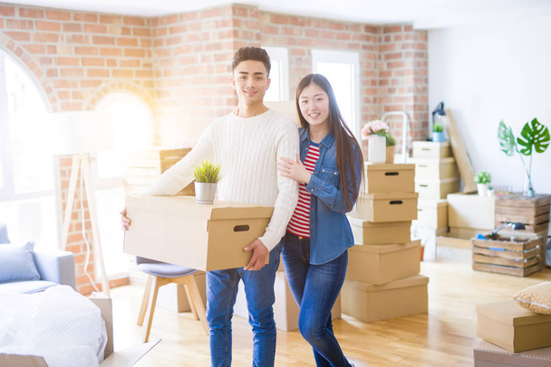 Bonito jovem asiático casal olhando feliz e sorrindo animado movendo-se para uma nova casa
 - Foto, Imagem