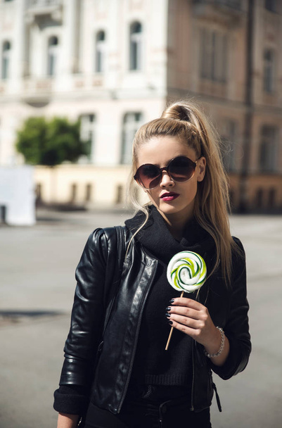 Young beautiful woman with lollipop in city - Zdjęcie, obraz