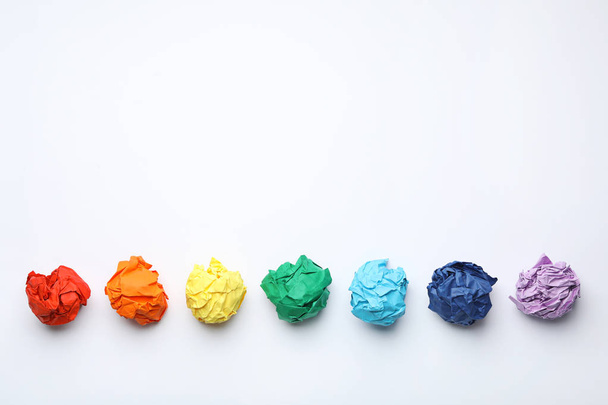 Colorful crumpled sheets of paper on white background, top view - Fotó, kép