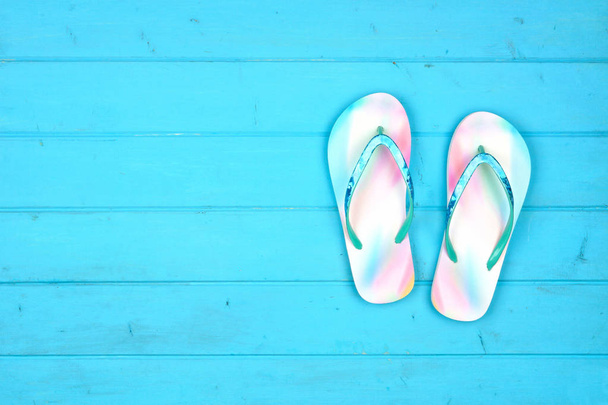 Summer flip flops on a blue wood background. Summer vacation concept. Top view with copy space. - Foto, imagen