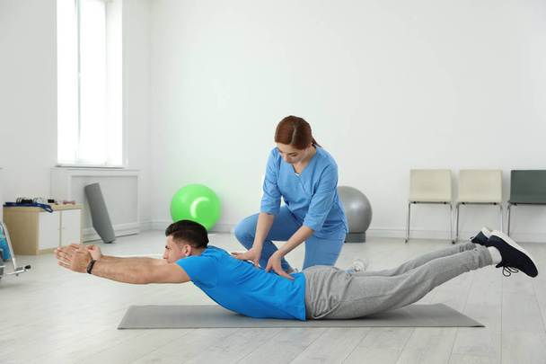 Professional physiotherapist working with male patient in rehabilitation center - Foto, Imagem