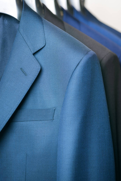 close up luxurious style gentlemen suit row, hanging in a closet. - Photo, Image