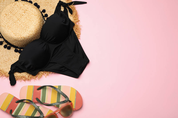 Flat lay composition with swimsuit and beach accessories on color background. Space for text - Foto, afbeelding
