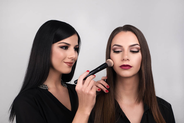 Portrait of young  beautiful women applying make up - Foto, Imagen