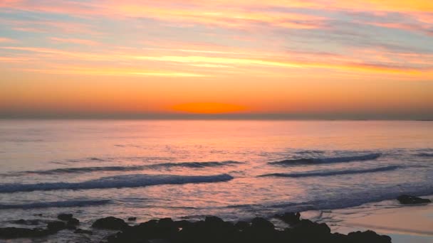 Piękne fale Oceanu Atlantyckiego z refleksjami zachodu słońca na powierzchni wody na plaży Carcavelos, - Materiał filmowy, wideo