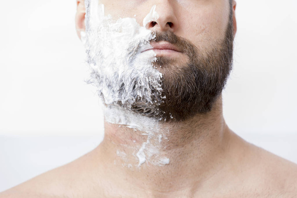 Чоловік з половиною обличчя в кремі для гоління
 - Фото, зображення