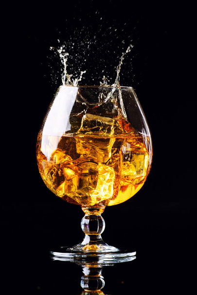 glass with cognac on a black background - Fotoğraf, Görsel