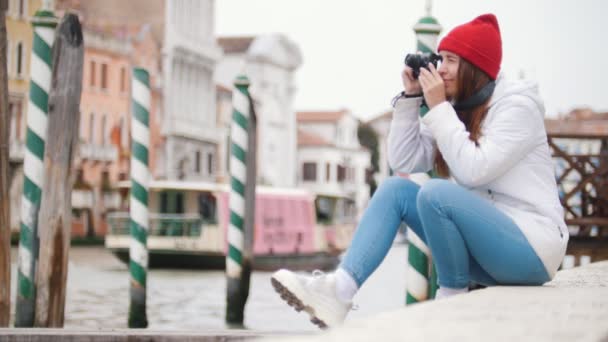 Mladá žena sedí na betonových blocích a fotí všude kolem - Záběry, video