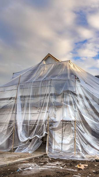 Rama pionowa dom w budowie pokryte plastikową Agą - Zdjęcie, obraz