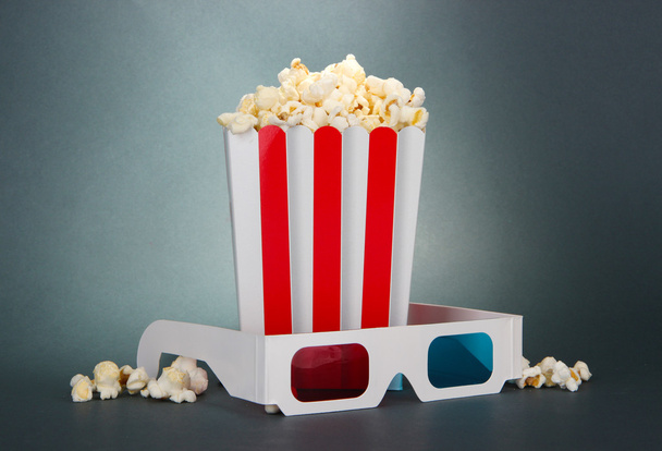Popcorn and 3D glasses on grey background - Photo, image