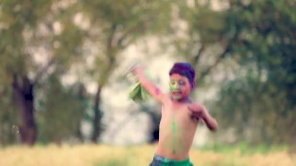 Niño indio juega con el color en el festival de holi - Imágenes, Vídeo