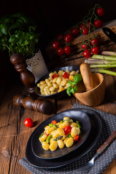 crispy gnocchi with roasted asparagus and tomatoes - Φωτογραφία, εικόνα