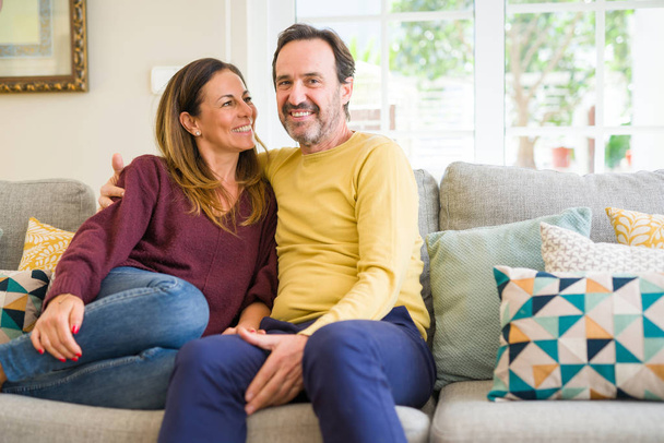 Middle age romantic couple sitting on the sofa at home - Foto, immagini