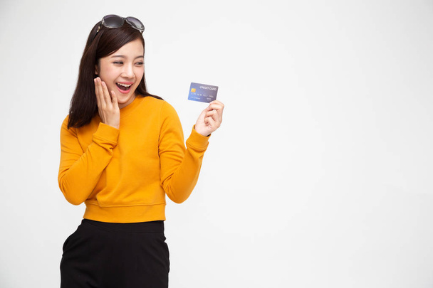 Happy Asian woman holding credit card or cash advances, Pay instead of money and specially curated benefits for lady card concept - Photo, Image