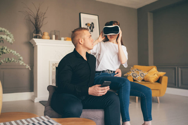 young couple spend time together playing VR in living room  - Foto, Bild