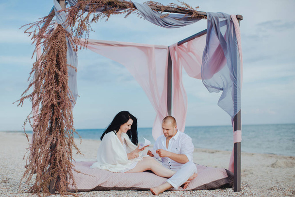 Couple sitting on the beach - Фото, изображение