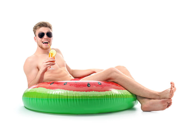 Funny young tourist with inflatable ring and cocktail on white background - Foto, Imagen