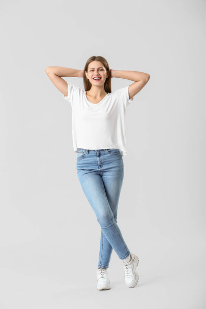 Beautiful young woman in jeans on white background - Foto, Imagem